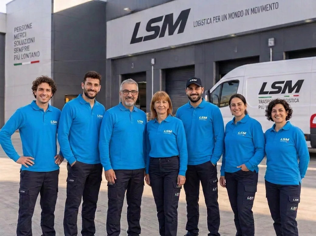 I sette membri del team LSM, tra cui il titolare e sua madre, con maglie azzurro royal e logo bianco, davanti al magazzino e a un furgone aziendale.